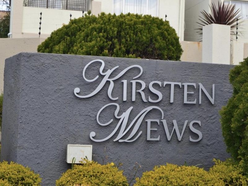 A clear view of the Kirsten Mews complex signage mounted on a textured boundary wall with integrated electric fencing.