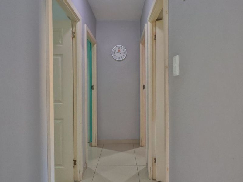 A functional interior hallway featuring tiled flooring and multiple internal door access points.
