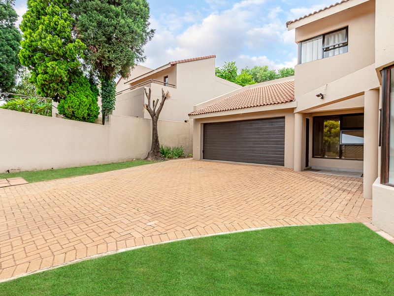 Front exterior view of the property featuring a paved driveway, a single garage, and a well-maintained lawn area.