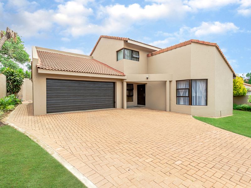 Front elevation of a double-storey house featuring a paved driveway, double garage, and well-maintained exterior finishes.