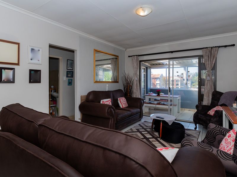 A living room featuring tiled flooring and a sliding glass door that provides access to an attached balcony.