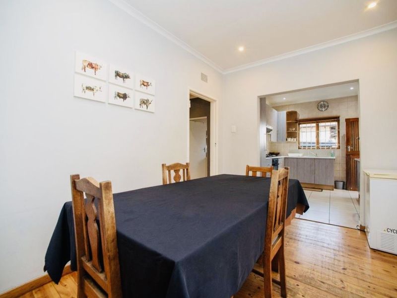 Open plan dining area featuring hardwood flooring and recessed lighting, with a clear view into the adjacent kitchen space.