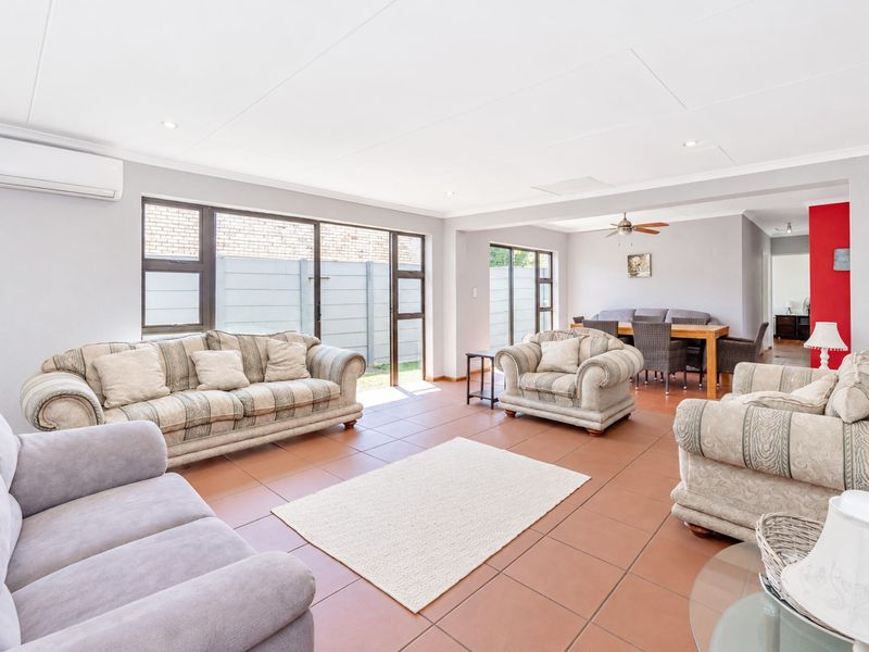 Spacious open-plan living and dining area featuring tiled flooring, recessed lighting, and large sliding doors providing access to the outdoor space.