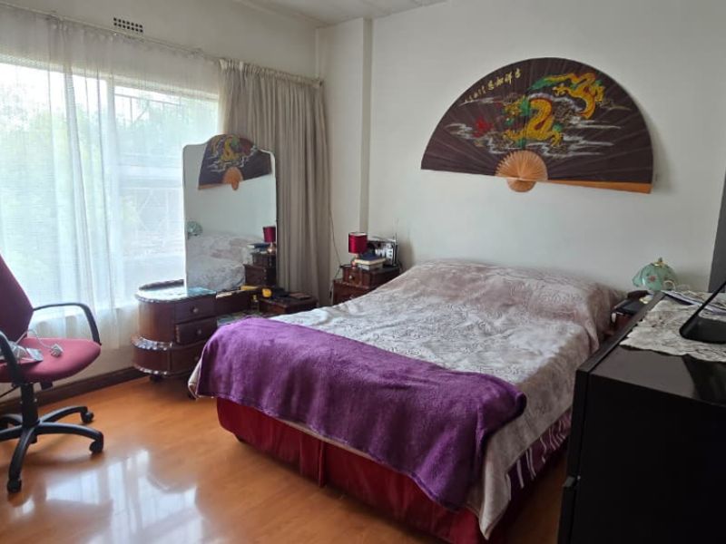 A bedroom featuring laminate flooring and a large window with curtain tracks, offering a functional space ready for modernization.