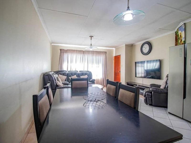 Open-plan living and dining area featuring tiled flooring and coved ceilings, providing a functional space for daily living and entertaining.