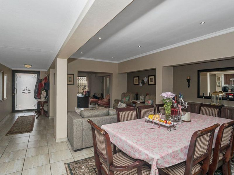 Spacious open-plan living and dining area featuring tiled flooring, recessed lighting, and built-in cabinetry, creating a functional and connected layout.