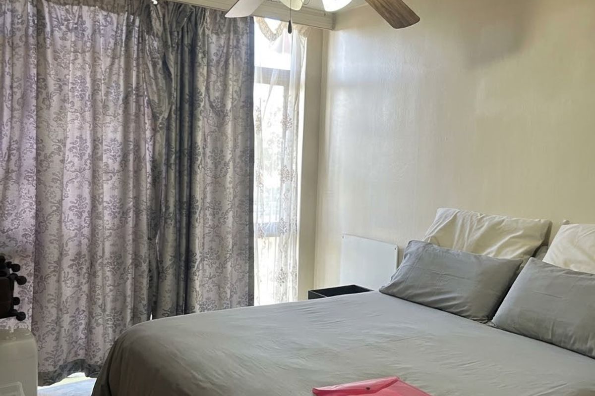 A bedroom featuring tiled flooring, a ceiling fan, and a sliding glass door providing access to the exterior.