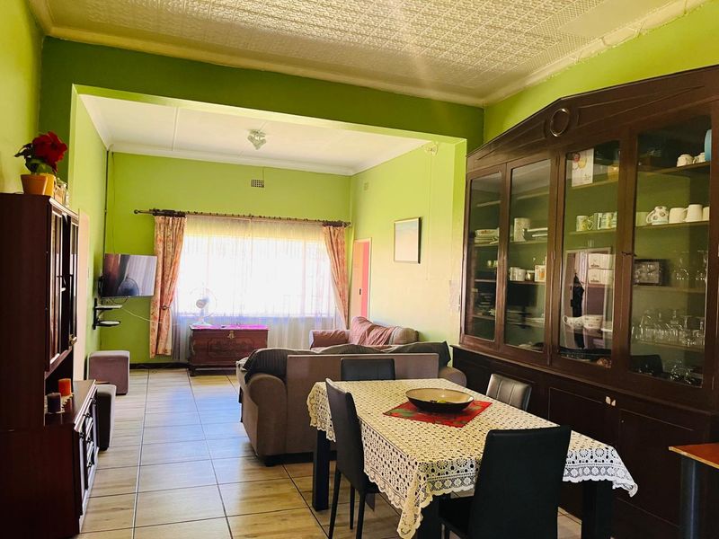 Spacious open-plan living and dining area featuring tiled flooring and a textured ceiling, offering a versatile layout for family living.