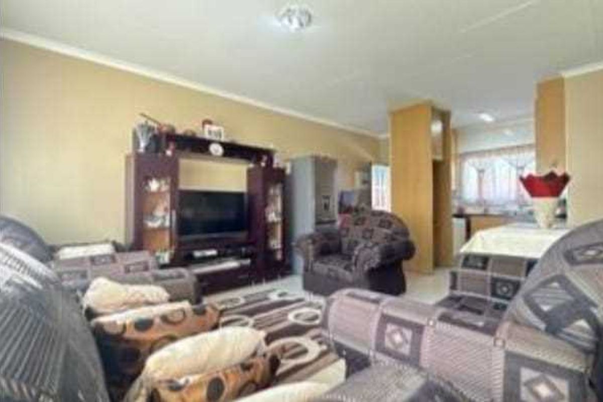 Open plan living area featuring tiled flooring and built-in cabinetry, seamlessly connecting to the kitchen space.