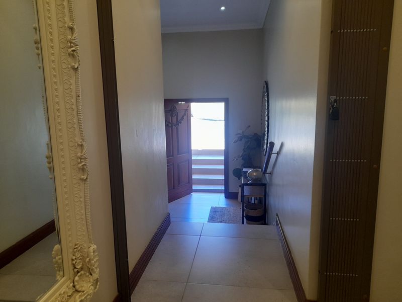 A welcoming entrance hall featuring tiled flooring and recessed lighting, leading directly to the main front door.