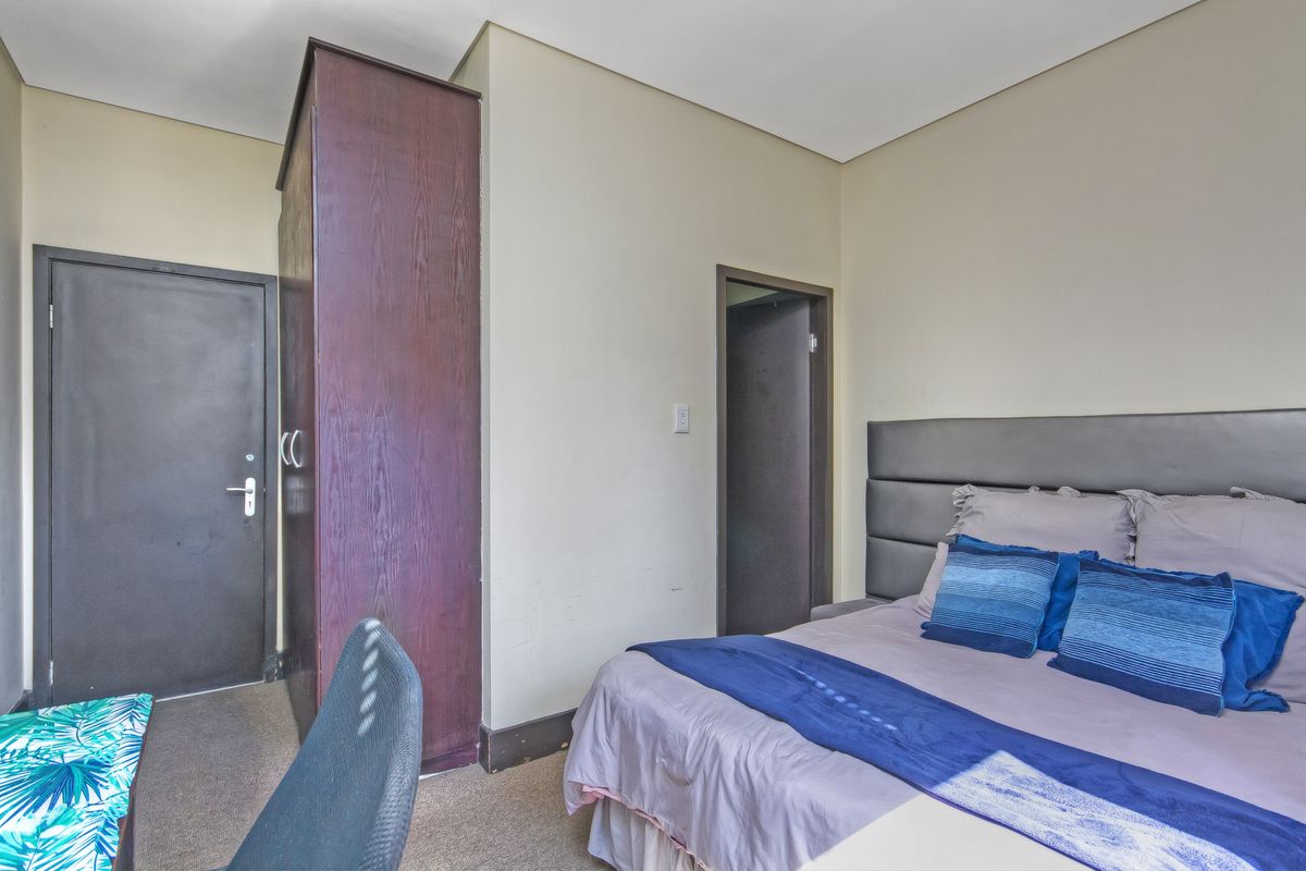 A bedroom featuring carpeted flooring and a built-in wardrobe, providing functional storage space within the room.