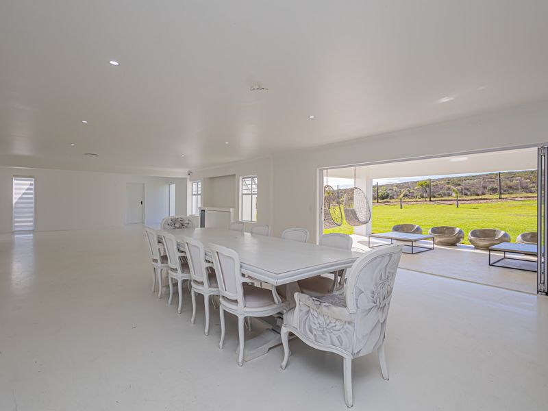 Spacious open-plan living and dining area featuring seamless indoor-outdoor flow through large bi-fold doors leading to a patio and garden.