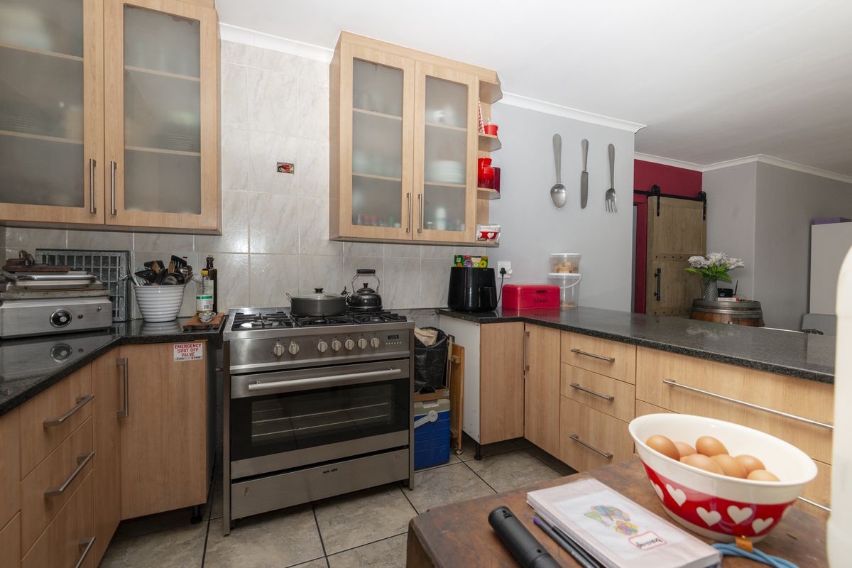 Functional kitchen featuring light wood cabinetry, granite countertops, tiled backsplash, and a stainless steel gas stove with oven.