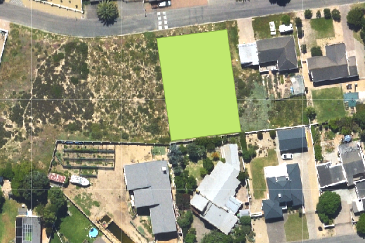 An aerial view of a vacant residential plot highlighted in green, situated within an established suburban neighborhood.