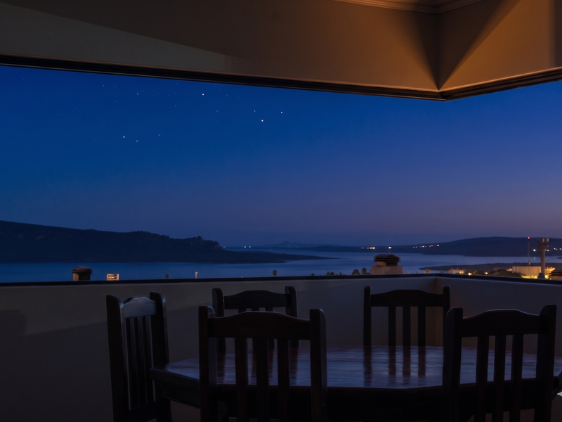 A stunning evening view overlooking a tranquil bay and distant hills, captured from a private balcony.