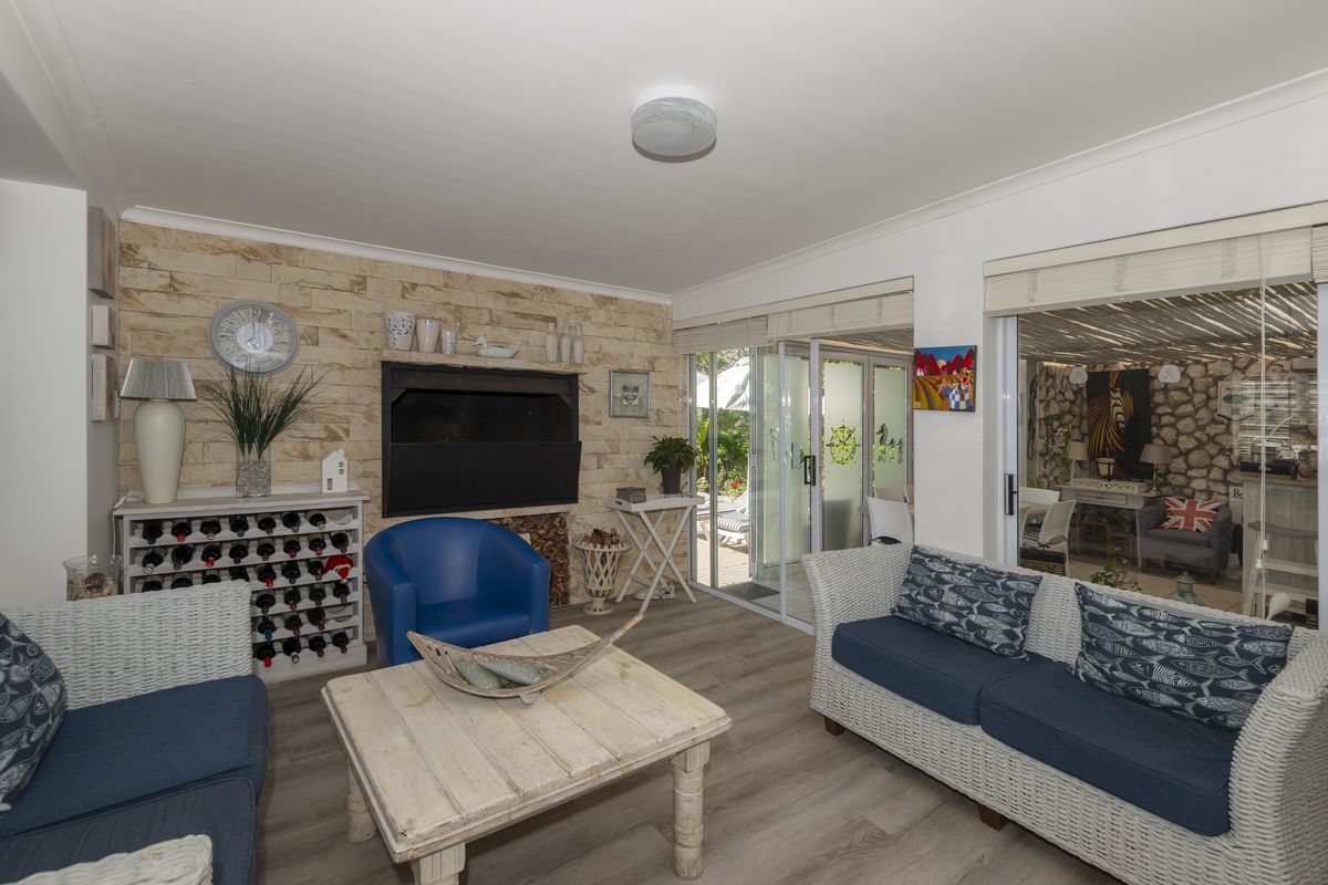 A comfortable living room featuring a stone accent wall with a built-in fireplace and sliding glass doors providing access to the outdoor area.