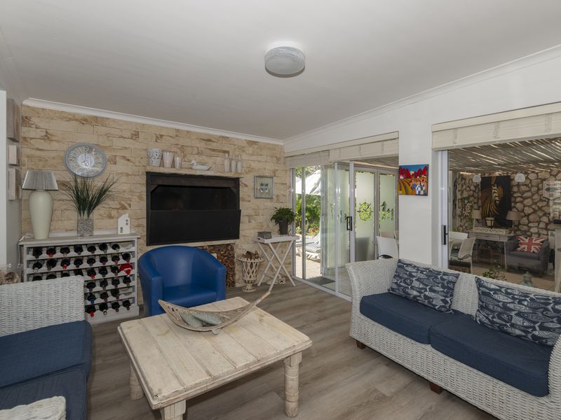 A comfortable living room featuring a stone accent wall with a built-in fireplace and sliding glass doors providing access to the outdoor area.