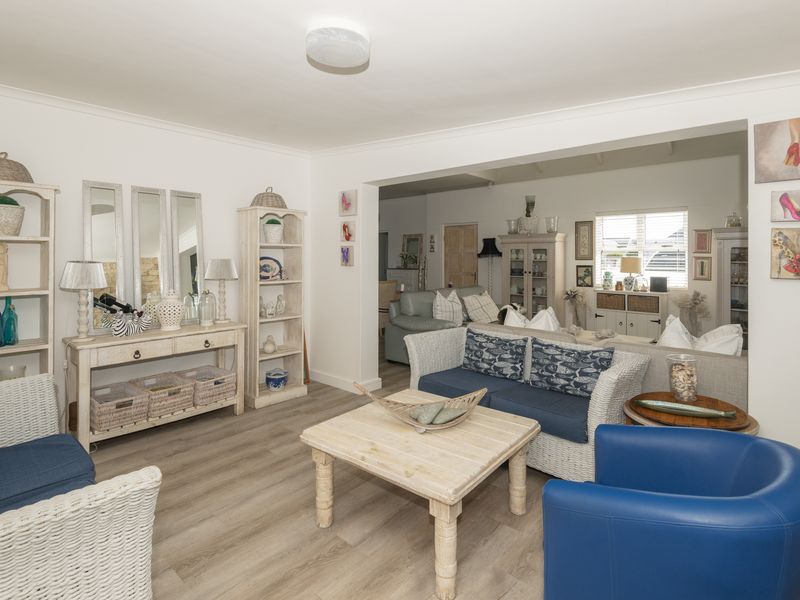 Spacious open-plan living area featuring light-toned laminate flooring and neutral walls, providing a versatile layout for comfortable family living.