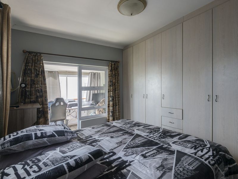 Bedroom featuring extensive built-in cupboards and a sliding door providing access to an adjoining space.