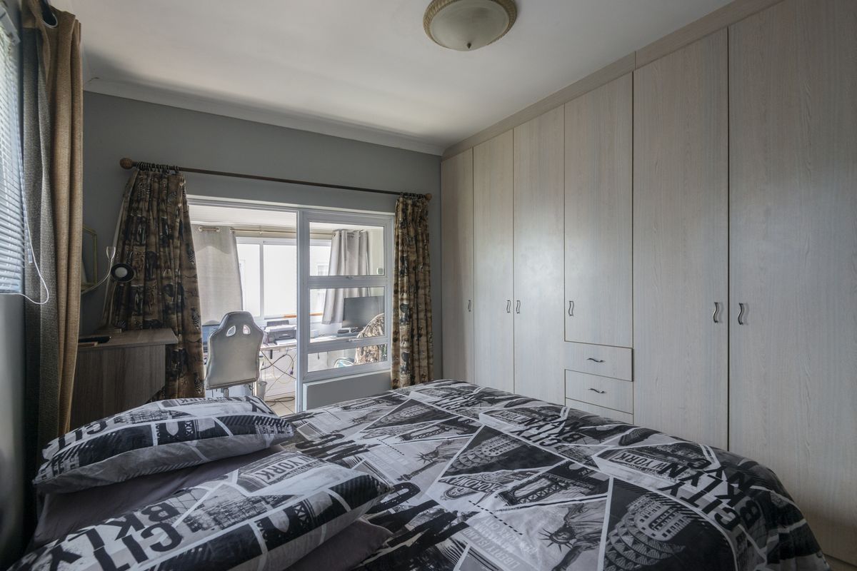 Bedroom featuring extensive built-in cupboards and a sliding door providing access to an adjoining space.