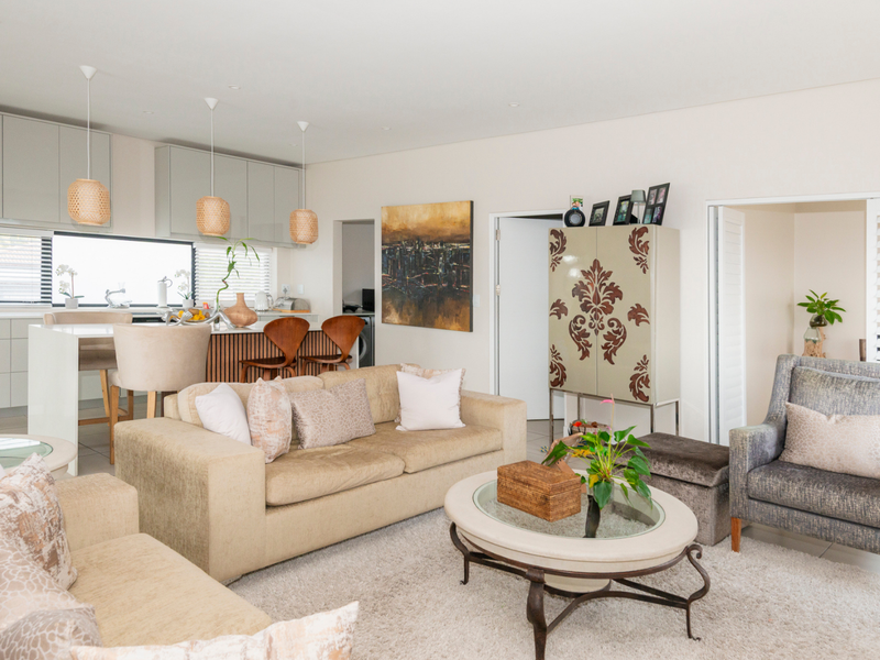 Spacious open-plan living area featuring a modern kitchen with built-in cabinetry, a central island, and seamless flow to the lounge space.