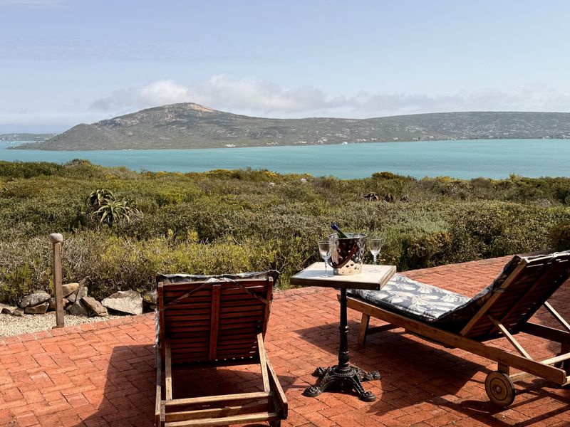 A scenic outdoor patio area featuring brick paving and an expansive, unobstructed view of the lagoon and surrounding landscape.