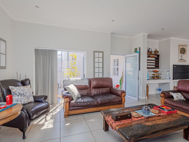 Spacious open-plan living area featuring tiled flooring, recessed lighting, and a sliding glass door leading to the exterior.