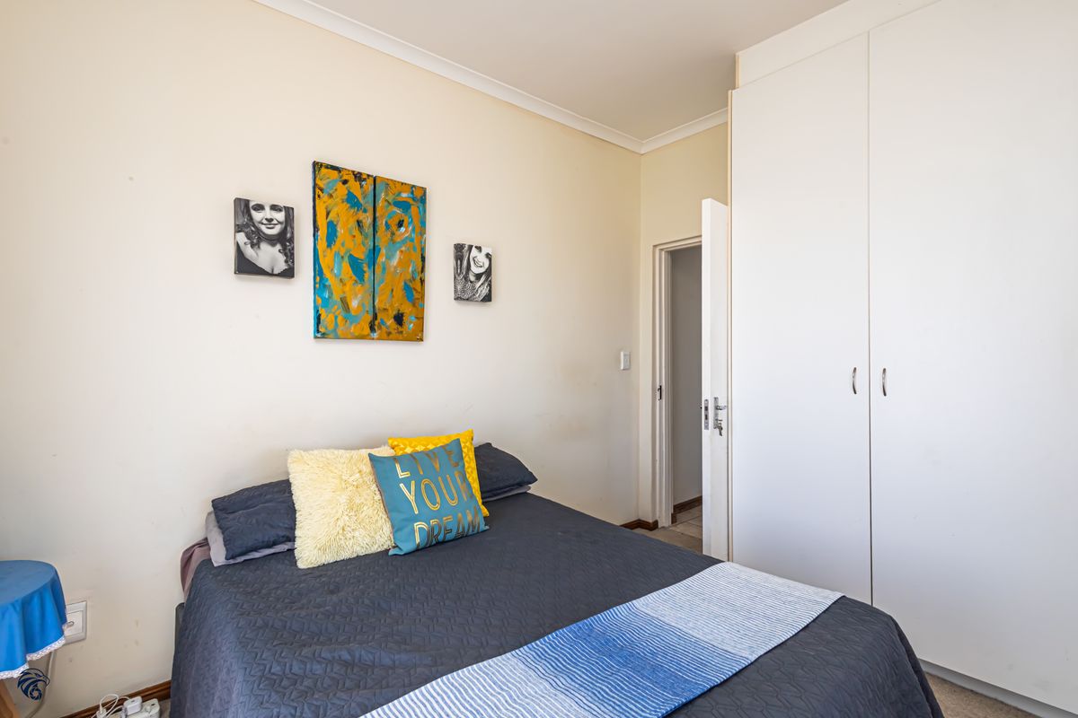 A functional bedroom featuring built-in cupboards and neutral wall finishes, providing a practical space with standard architectural detailing.