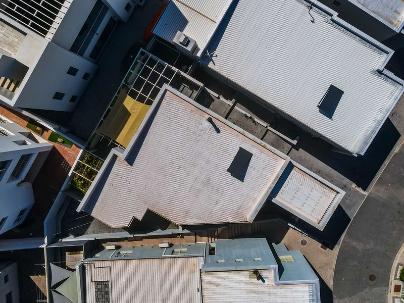 An aerial view of the property showing the roof structure, skylight, and surrounding residential layout.