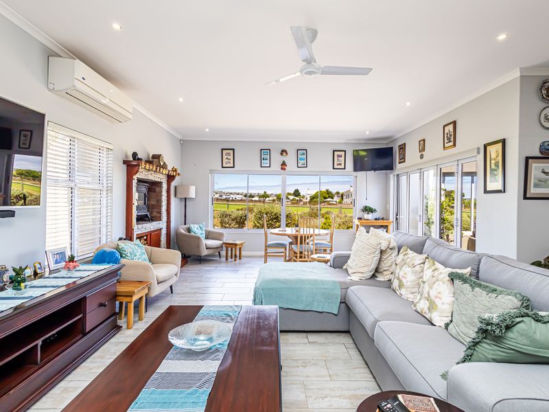 Spacious living room featuring tiled flooring, a built-in fireplace, split-system air conditioning, and large windows providing ample natural light and scenic views.