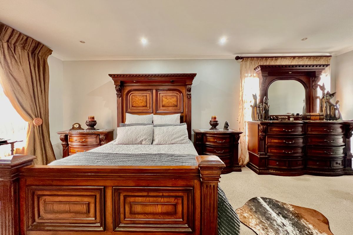 A spacious bedroom featuring recessed ceiling lighting and neutral carpeting, providing a comfortable and well-maintained living space.