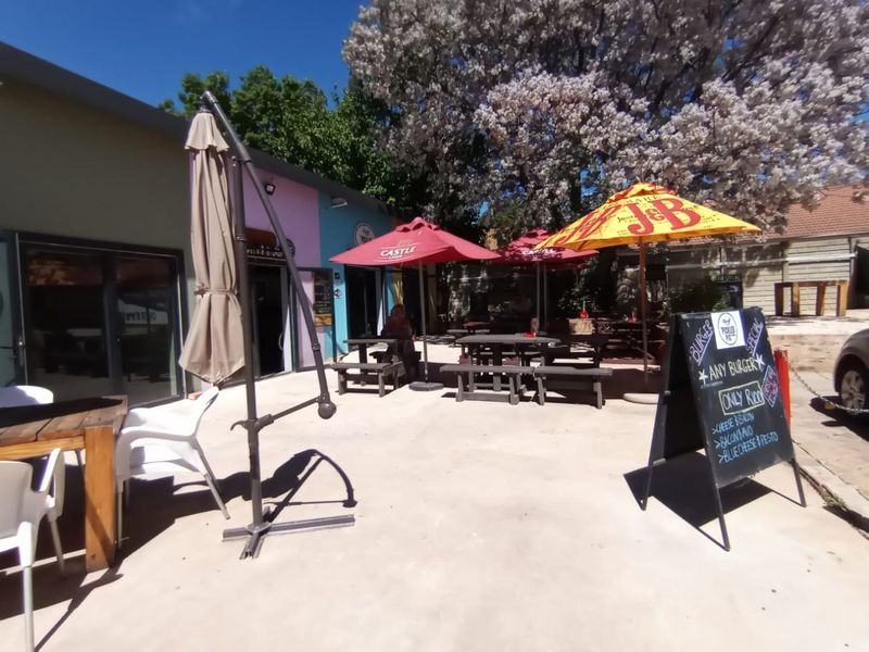 An outdoor patio area featuring paved flooring and access to the building via sliding glass doors, suitable for casual dining or social gatherings.