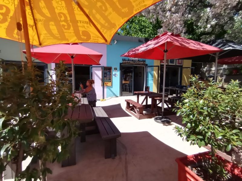 Outdoor patio area featuring paved flooring and access to the building interior through sliding glass doors, suitable for casual dining or social gatherings.