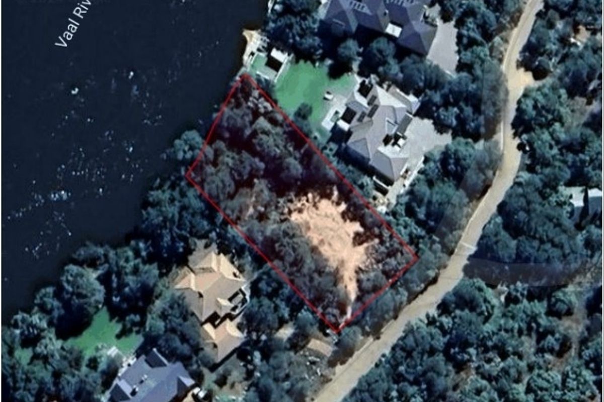Aerial view of a vacant residential plot situated along the Vaal River, featuring established trees and direct river access.