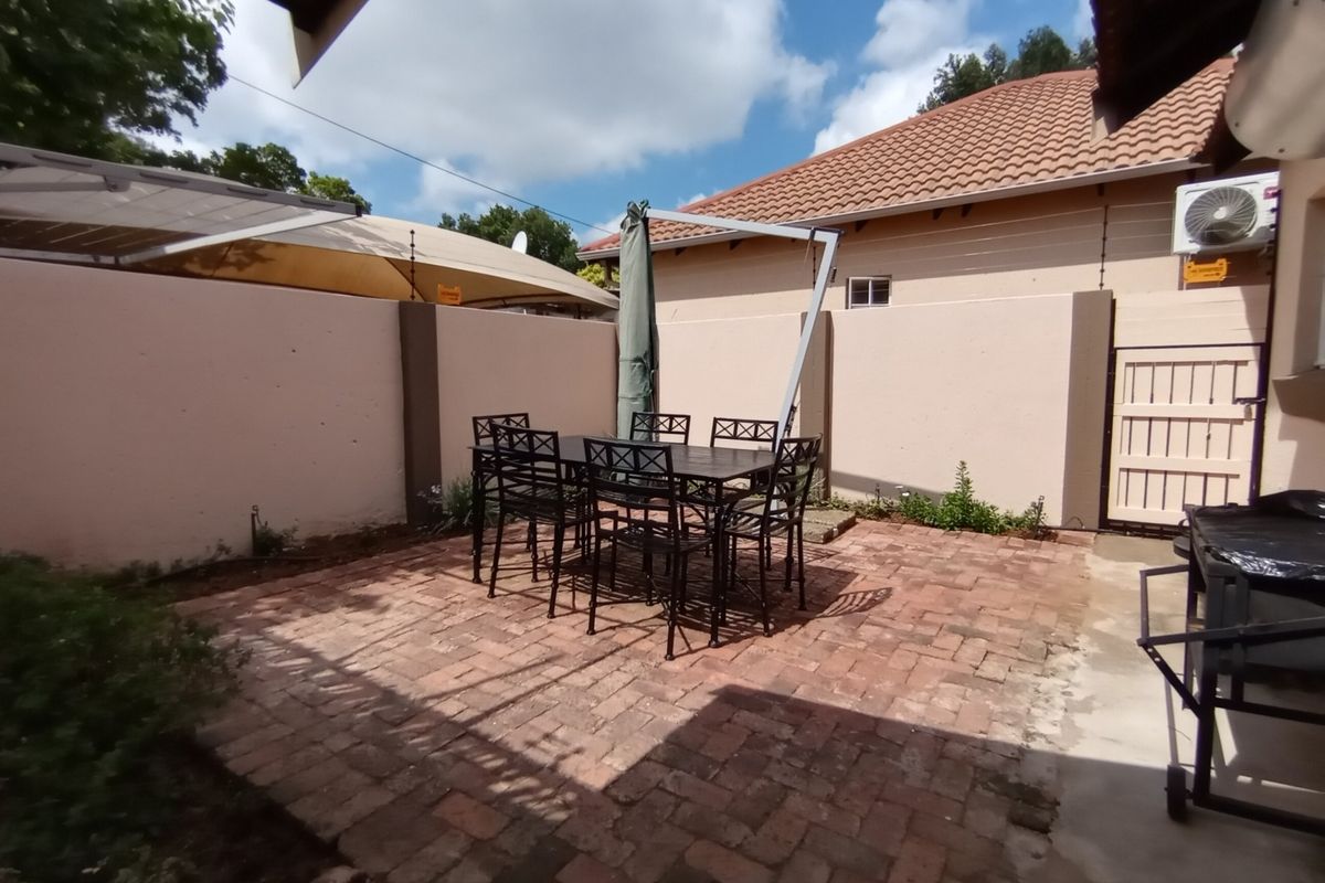 A private rear courtyard featuring brick paving, enclosed by perimeter walls, providing a functional outdoor entertainment space.