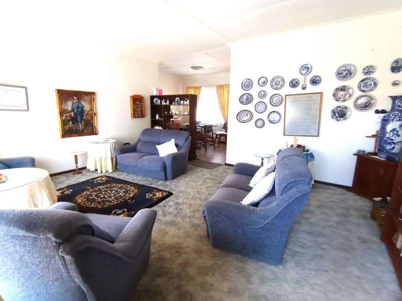 A spacious living room featuring fitted carpeting and neutral wall finishes, providing a comfortable and functional area for relaxation.
