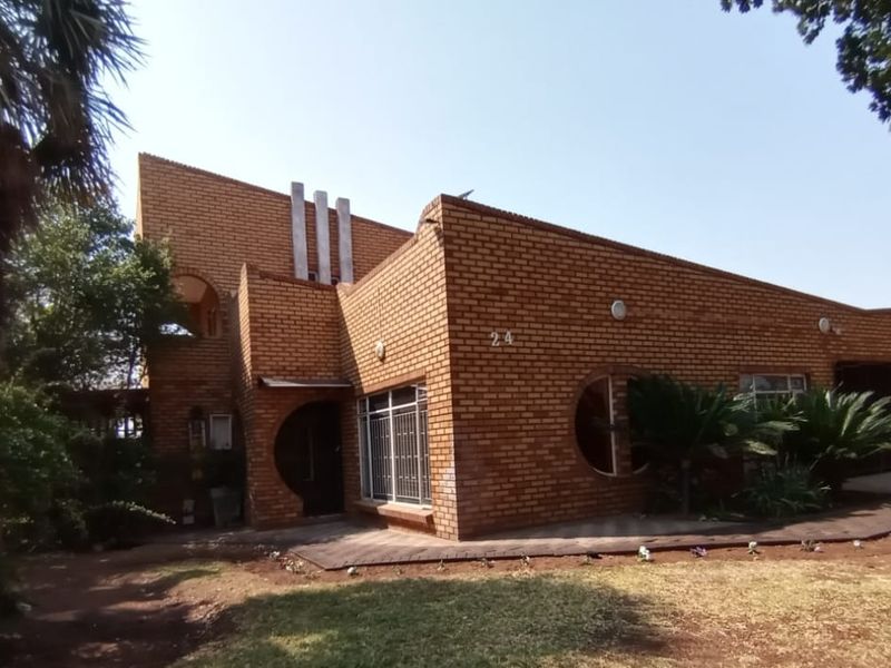 A distinctive face brick residential property featuring unique circular windows and a paved front walkway.
