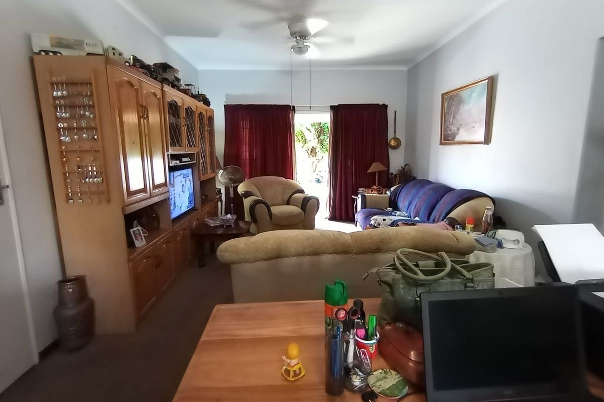 A living room featuring a ceiling fan and a sliding glass door providing access to the outdoor area.