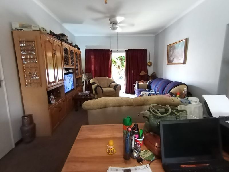 A living room featuring a ceiling fan and a sliding glass door providing access to the outdoor area.