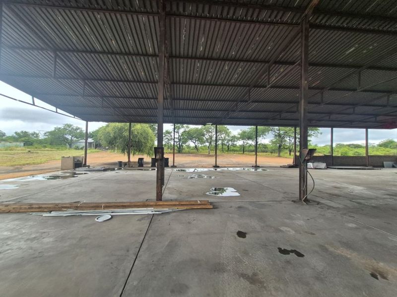 Large open-plan industrial utility space featuring a corrugated metal roof structure supported by steel columns and a concrete slab floor.