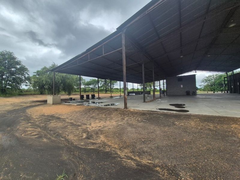 Large open-plan industrial shed featuring a steel frame structure, corrugated metal roofing, and a concrete slab floor, suitable for storage or workshop use.