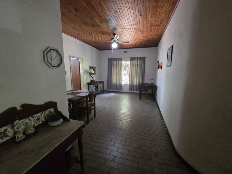 Spacious living area featuring a warm timber tongue and groove ceiling, tiled flooring, and a central ceiling fan.