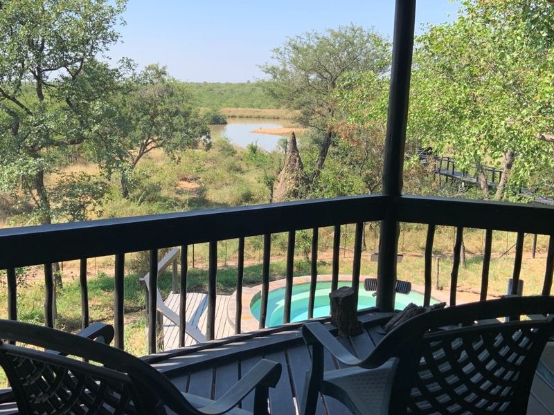 A covered balcony deck overlooking a natural landscape with a small plunge pool visible below.