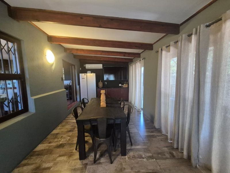 Dining room featuring exposed timber ceiling beams, tiled flooring, and built-in cabinetry with an integrated air conditioning unit.