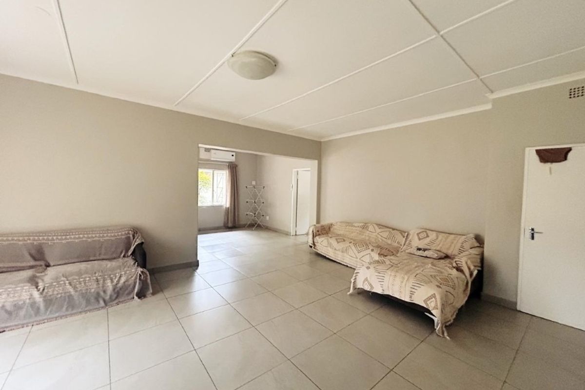 Spacious living area featuring neutral tiled flooring and a clean ceiling finish, offering a versatile layout for comfortable family living.