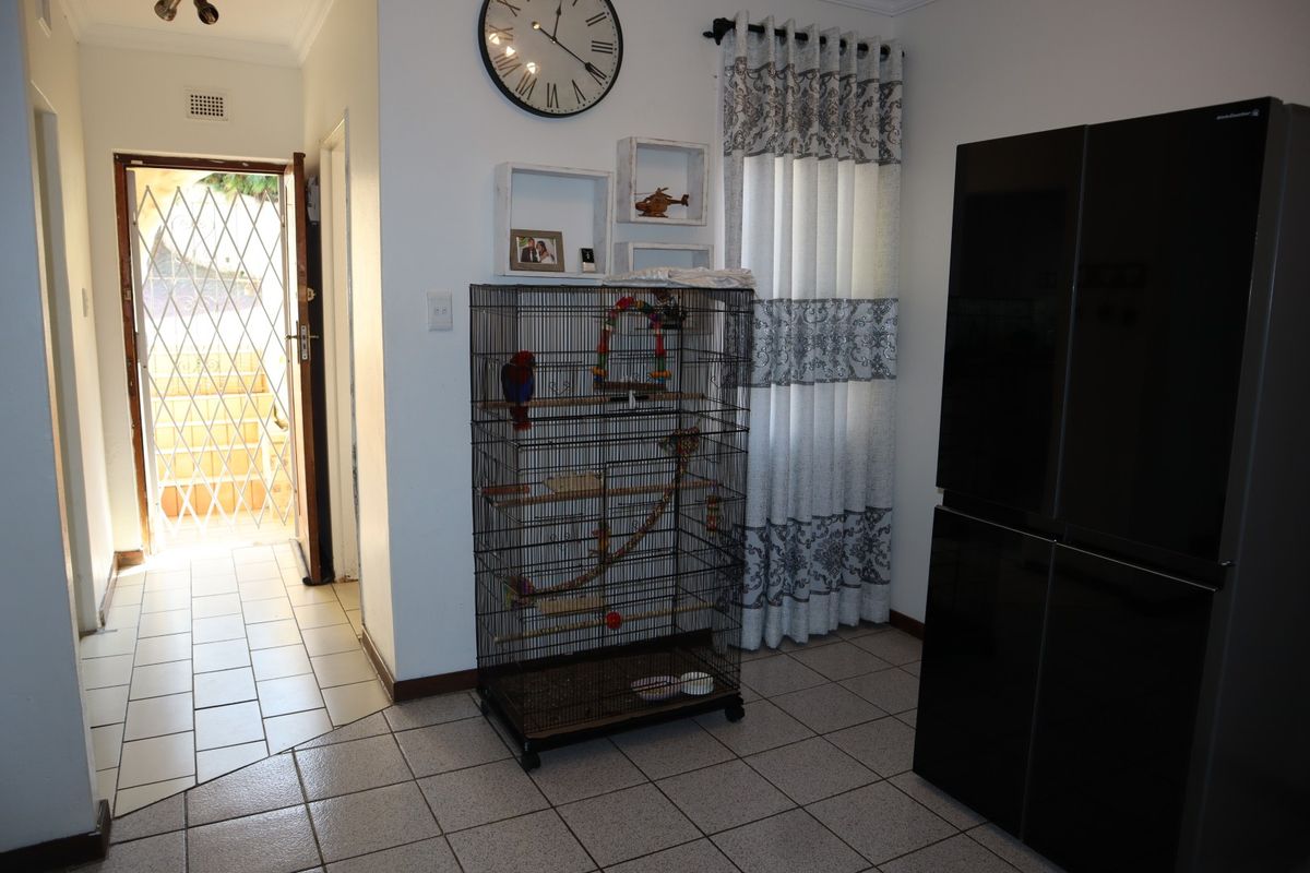 A kitchen area featuring tiled flooring and a direct access point to the exterior via a security gate.