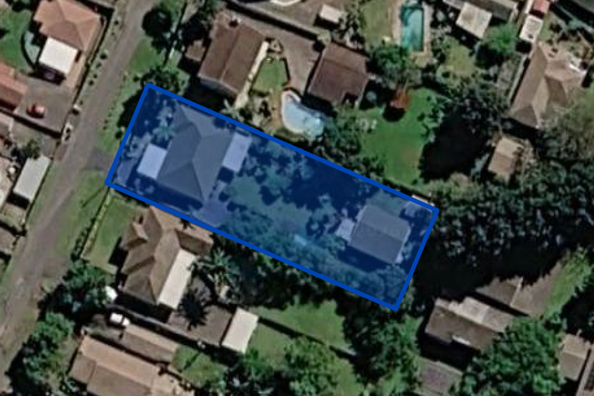An aerial satellite view of the residential property showing the building footprint, roof structure, and surrounding garden area.
