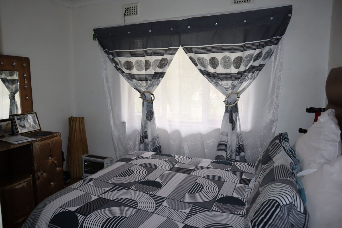 A bedroom featuring a window with built-in ventilation, providing natural light and a functional layout for a sleeping space.