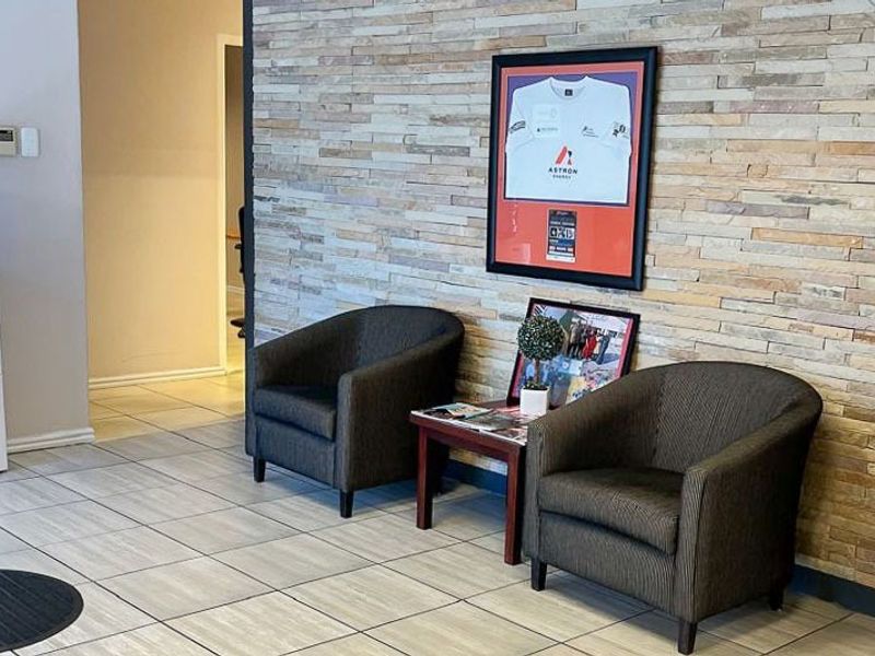 A commercial entry area featuring a decorative stacked stone feature wall and neutral ceramic tile flooring.