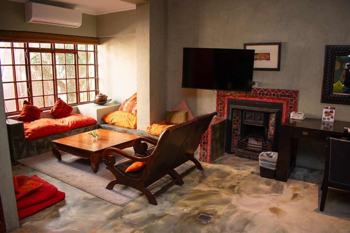 A cozy living room featuring a decorative tiled fireplace, polished concrete floors, and a built-in window seat with natural light.
